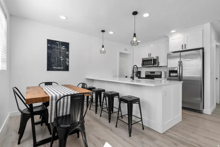 Unit #2White shaker cabinetry, stainless steel appliances, white countertops, recessed lighting, and wood-finish flooring