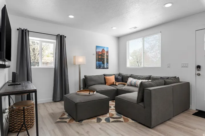 Unit #2Recessed ceiling lighting, wood-finish flooring, white walls, and multiple windows with blinds