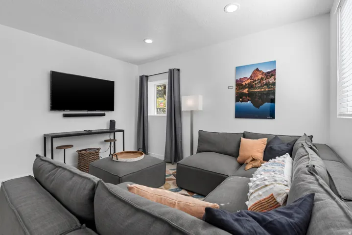 Unit #2Recessed ceiling lighting, wall-mounted television, console table, window with blinds, and drapery rods