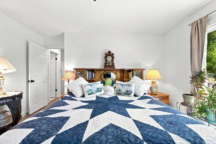 Hardwood-finish flooring, white paneled doors, and a window with natural light