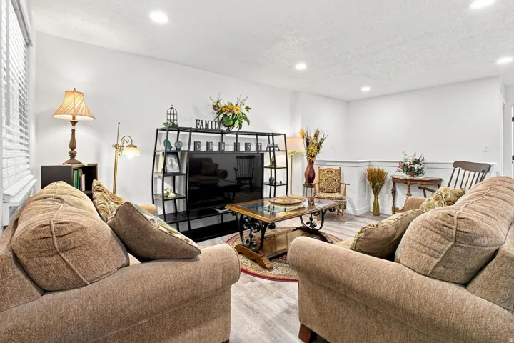 Recessed lighting, wood-finish flooring, white walls, and wainscoting detail