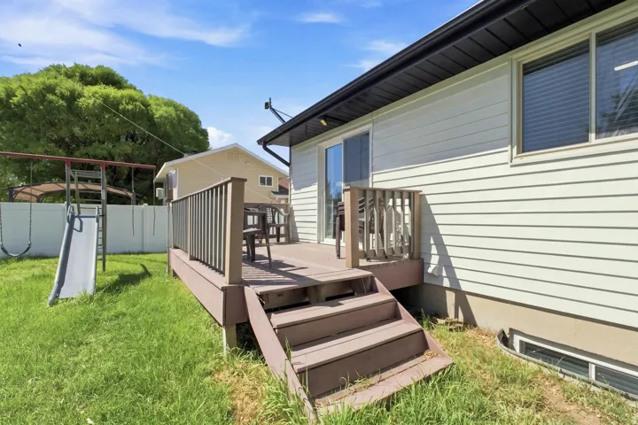 Private rear deck with steps to the grassy yard