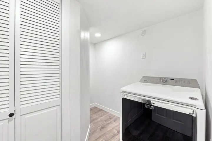 Louvered closet doors, wood-finish flooring, and recessed lighting