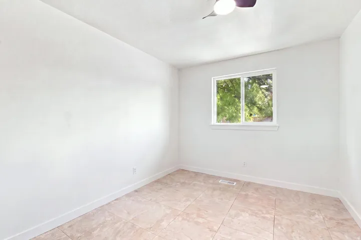 Recessed window offering natural light, ceiling fan, and tile flooring