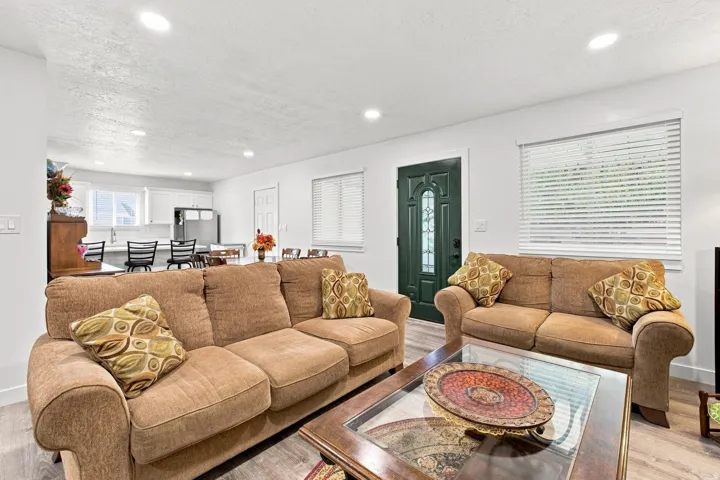Open-concept living space with recessed lighting, wood-finish flooring, and white walls