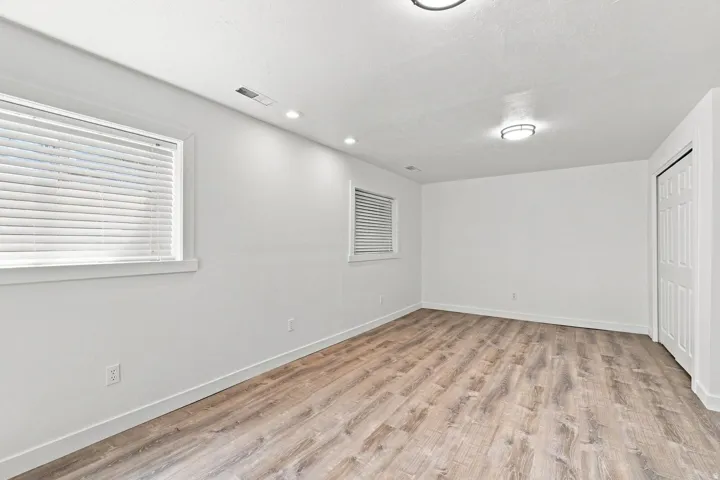 Recessed and flush-mount ceiling lighting, wood-finish flooring, and white walls