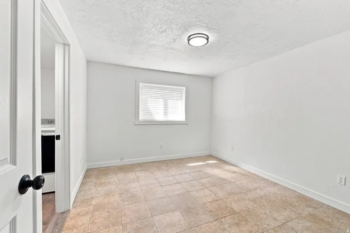 Tile flooring, white walls, and a window with blinds