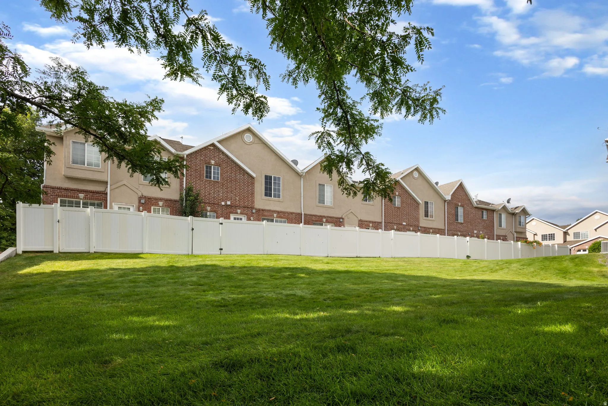 Expansive green space with a white privacy fence