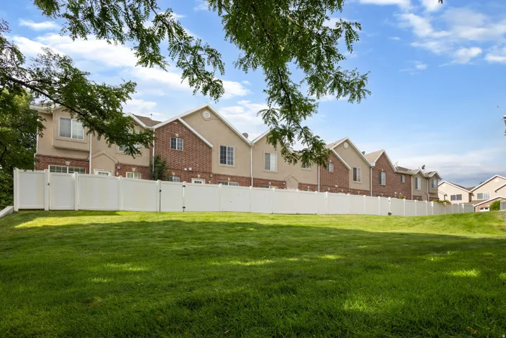 Expansive green space with a white privacy fence