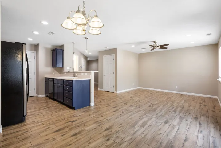 Open-concept living area with wood-finish flooring, recessed lighting, and a ceiling fan