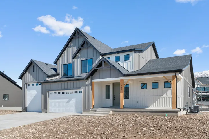 Contemporary exterior with board and batten siding, dark framed windows, a covered front porch with natural wood columns, and an attached two-car garage