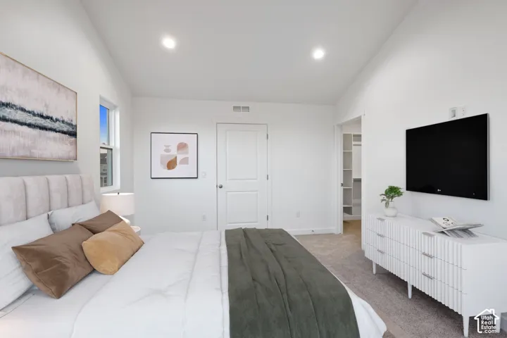 Recessed lighting, wall-to-wall carpeting, and a built-in closet with shelving