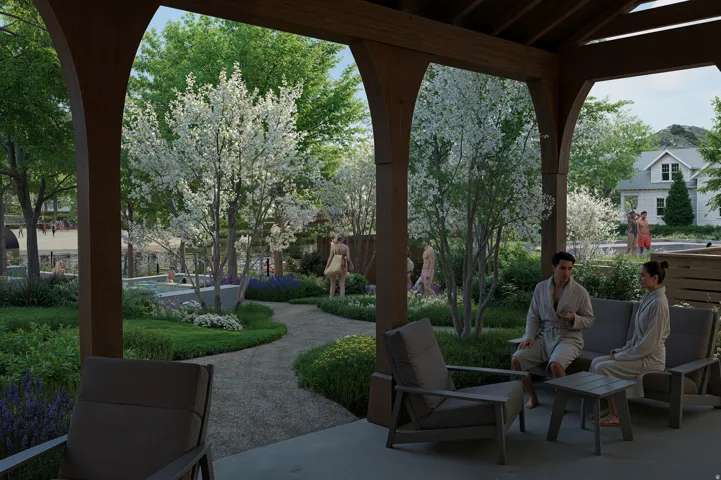 Covered outdoor seating area with exposed wood beams, concrete flooring, and lush landscaping