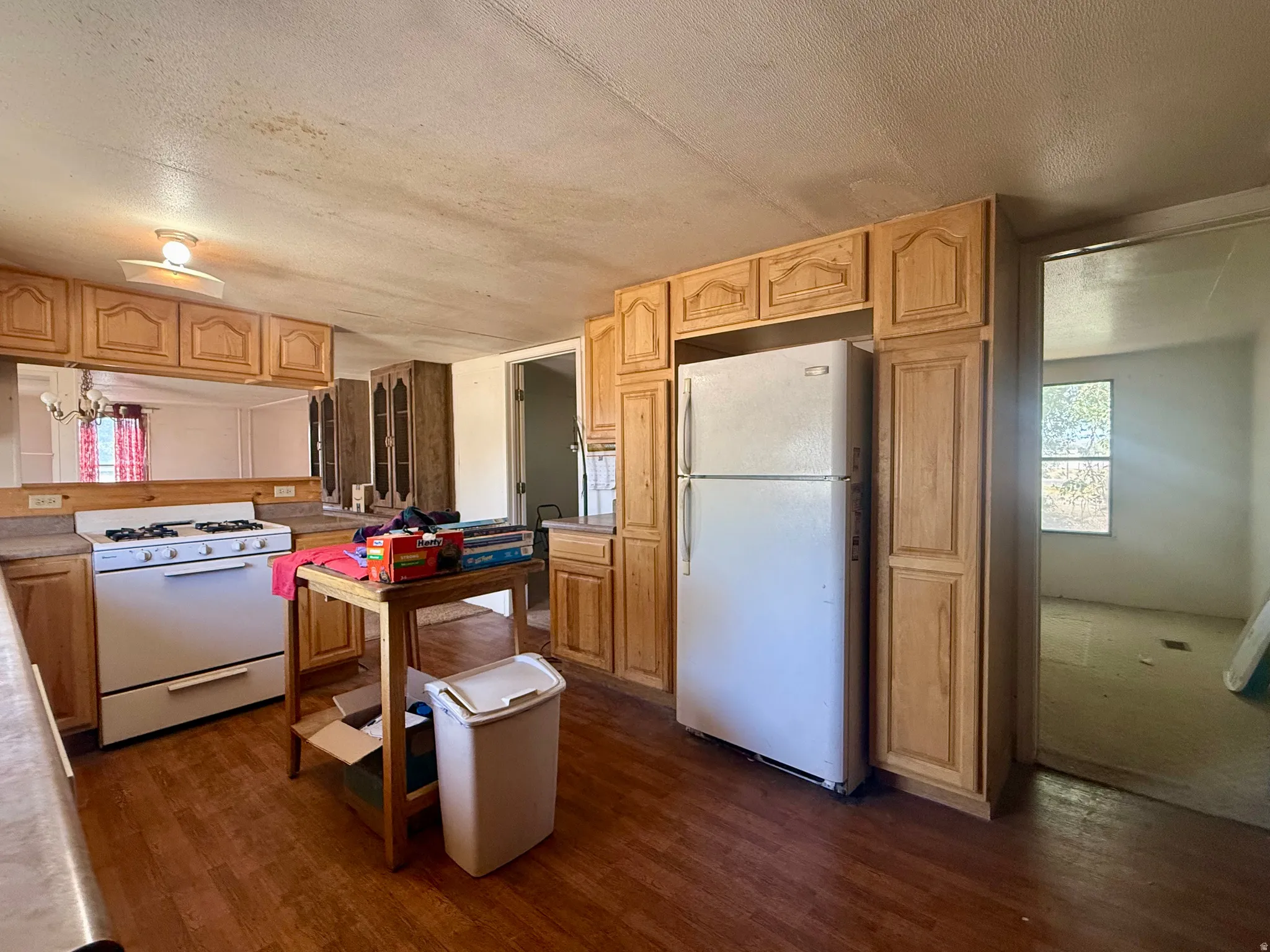 Wood-finish flooring, light wood cabinetry, and a white freestanding range