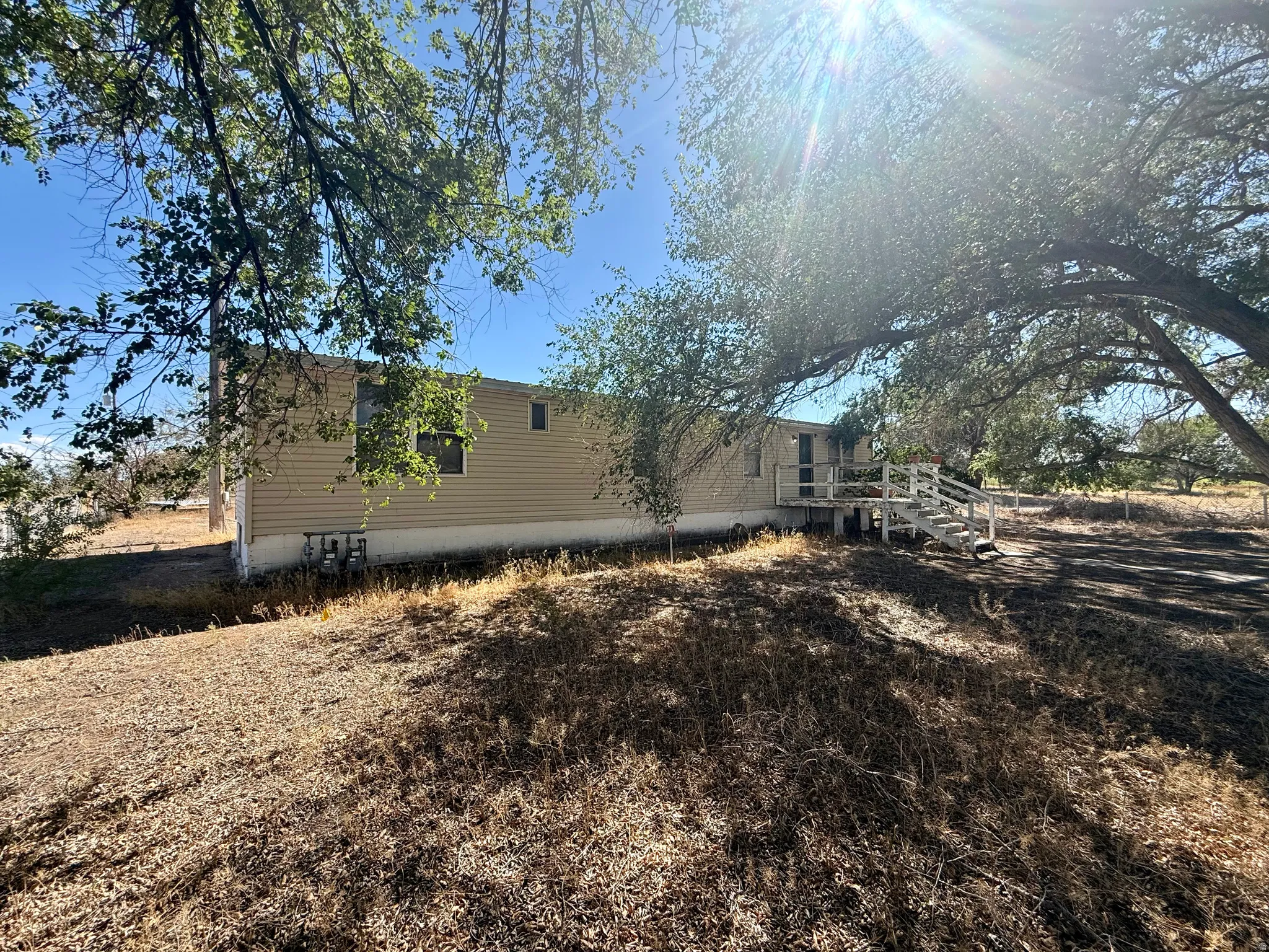 Siding exterior with multiple windows and a white wood deck with railing