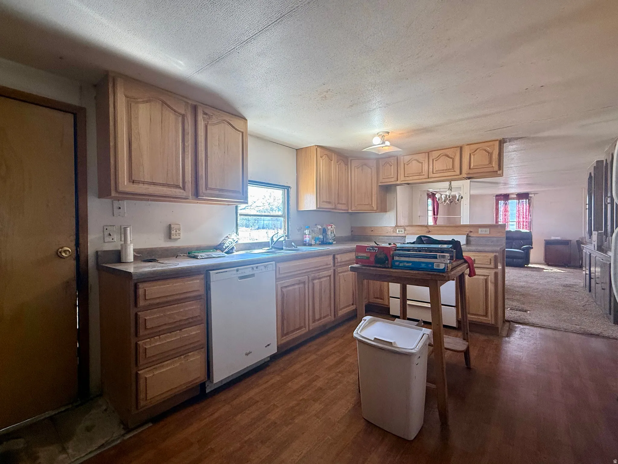 Kitchen featuring wood-finish cabinetry, laminate countertops, and a built-in dishwasher