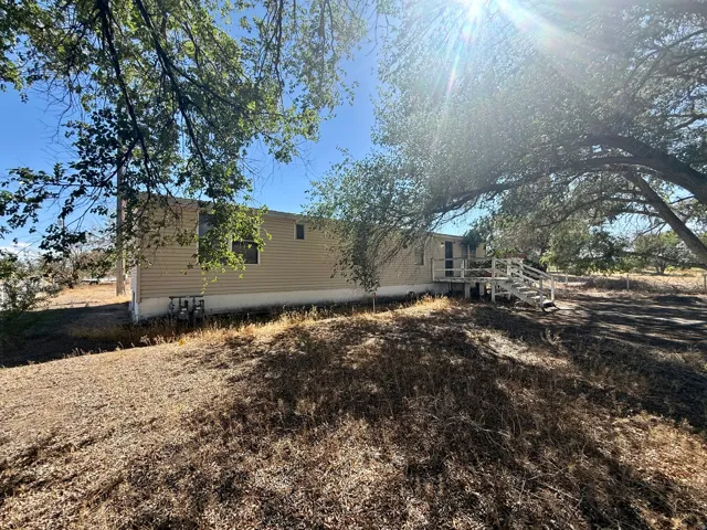 Siding exterior with multiple windows and a white wood deck with railing