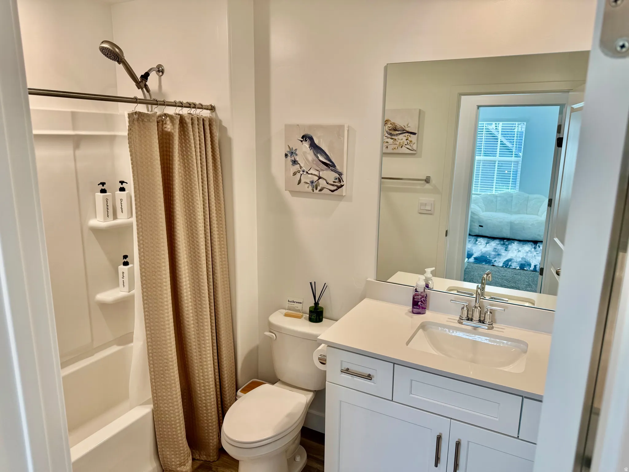 White vanity with brushed nickel hardware, a rectangular undermount sink, and a white countertop