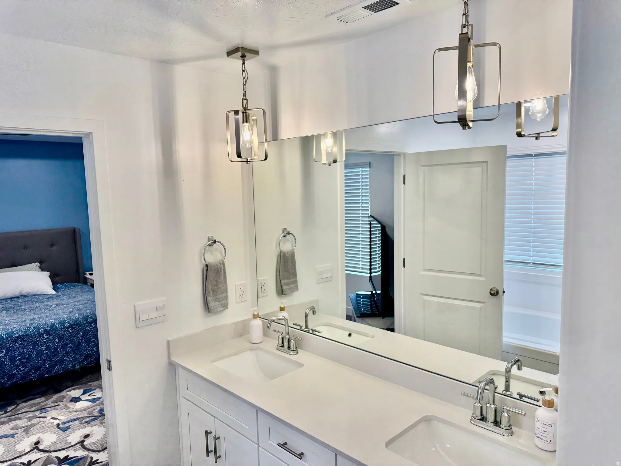 Dual vanity with undermount sinks, chrome fixtures, and white cabinetry