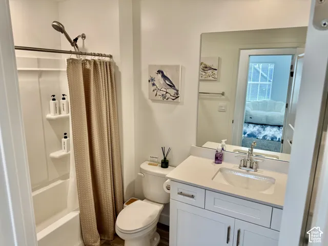White vanity with brushed nickel hardware, a rectangular undermount sink, and a white countertop