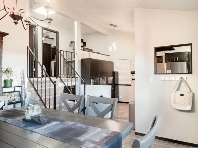 Open-concept living space with a dining area, multi-level design, and wrought iron stair railing