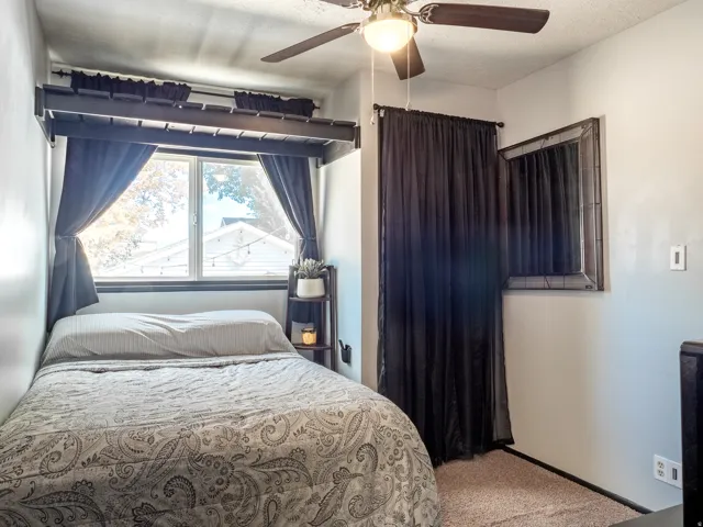 Built-in overhead shelving, ceiling fan with integrated lighting, framed wall mirror, and window with natural light