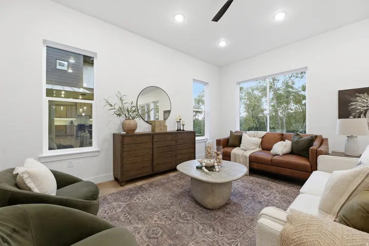 High ceilings with recessed lighting, large windows, and wood-finish flooring