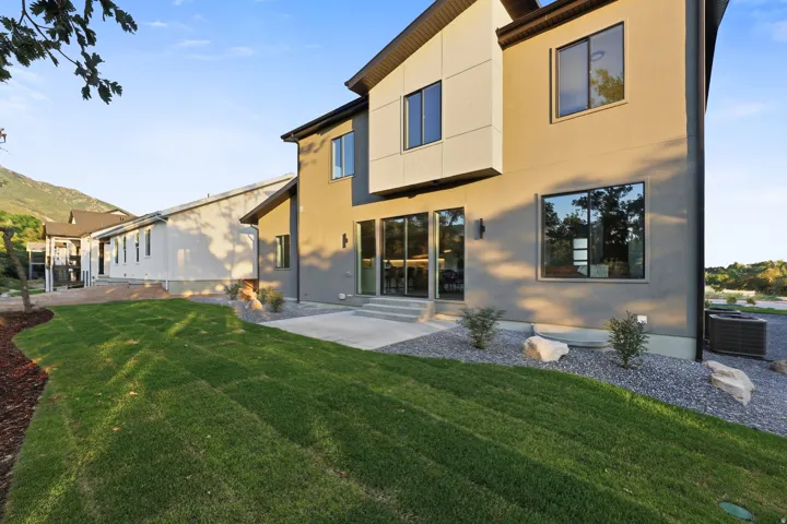 Contemporary exterior with large windows, sliding glass doors, and a concrete patio