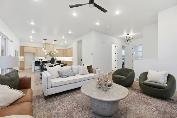 Open-concept living area with recessed lighting, wood-finish flooring, a modern ceiling fan, and a contemporary light fixture