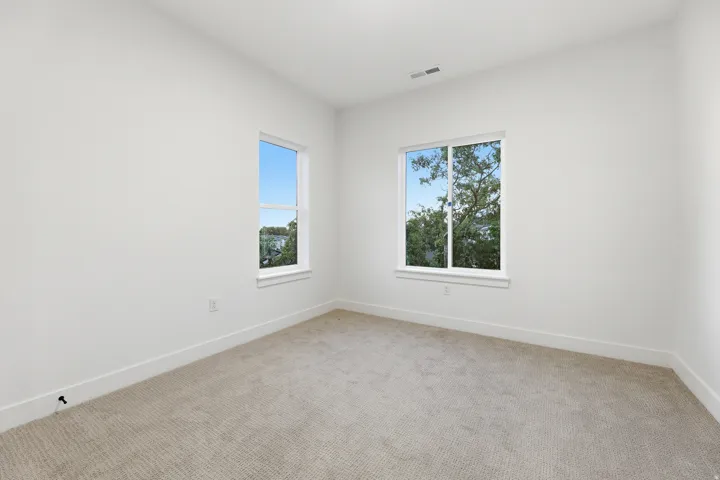 Bright interior space with light-toned carpet flooring and white painted walls
