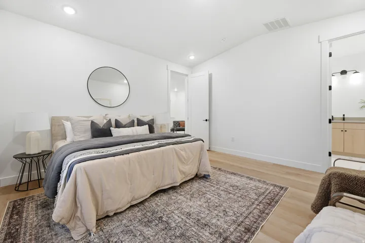 Recessed ceiling lighting, wood-finish flooring, white walls, and a sliding barn door