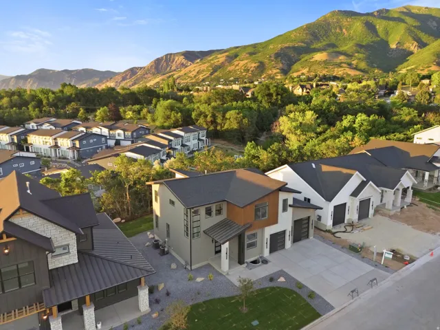 Contemporary architecture featuring varied exterior siding, paved driveway, and attached garage