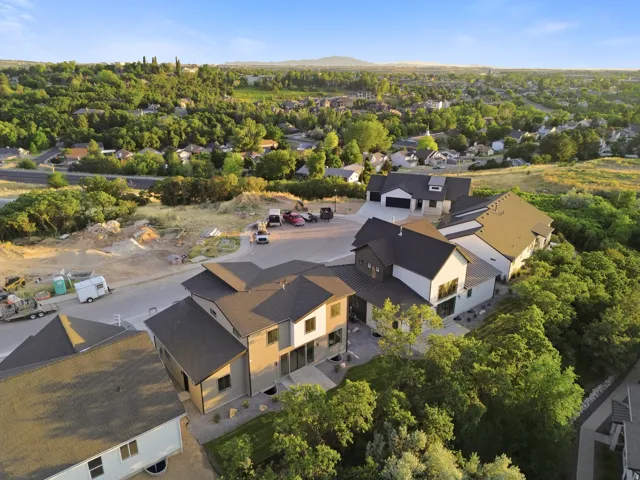 Modern residential architecture featuring multiple structures, dark-toned roofs, and light-colored exteriors