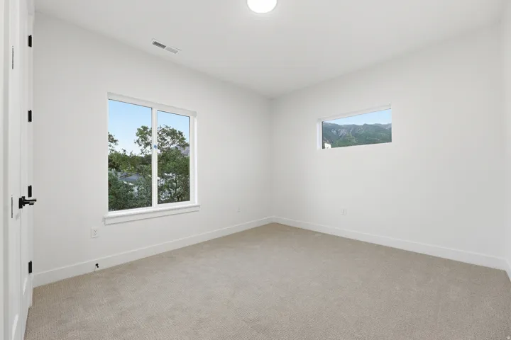 White walls, recessed ceiling lighting, light-colored carpeting, and white trim