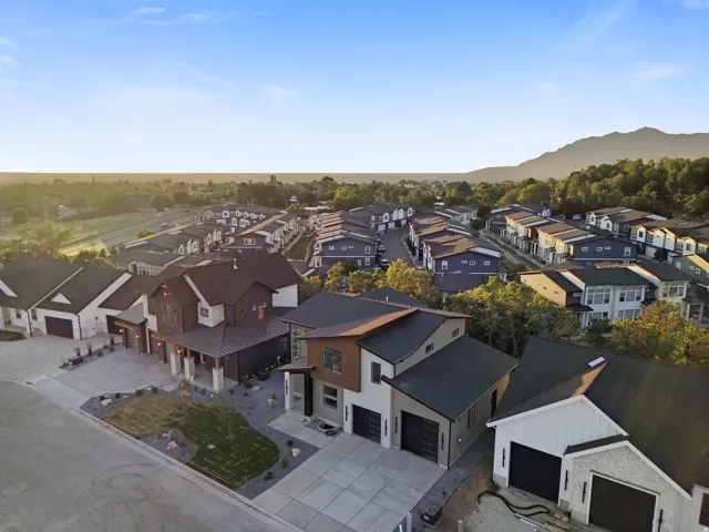 Contemporary architectural design featuring a multi-tone exterior, attached garage, and landscaped front yard