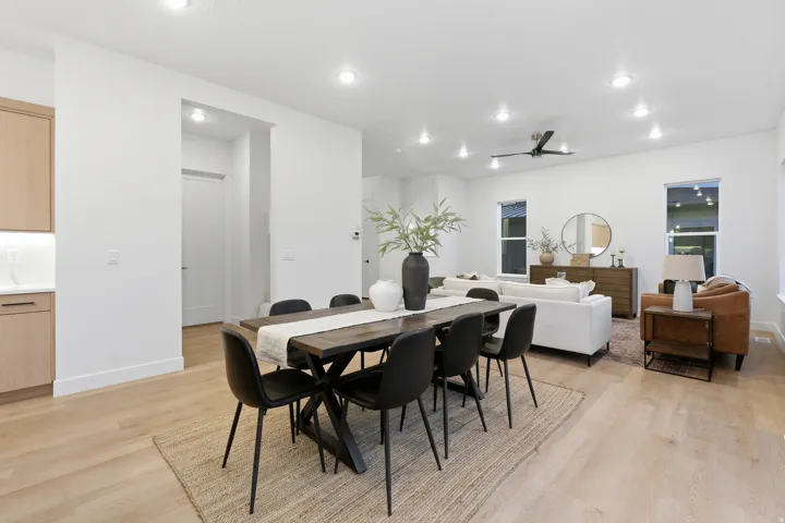 Open-concept living space with wood-finish flooring, recessed lighting, and a ceiling fan