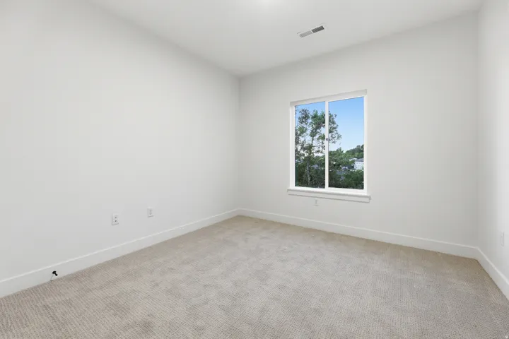 Carpeted flooring, white walls, and a large window with white trim