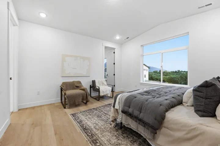 Vaulted ceiling, recessed lighting, wood-finish flooring, large window, crisp white walls