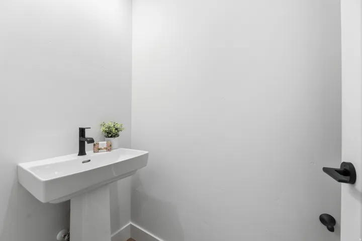 Pedestal sink with a rectangular basin and a matte black faucet