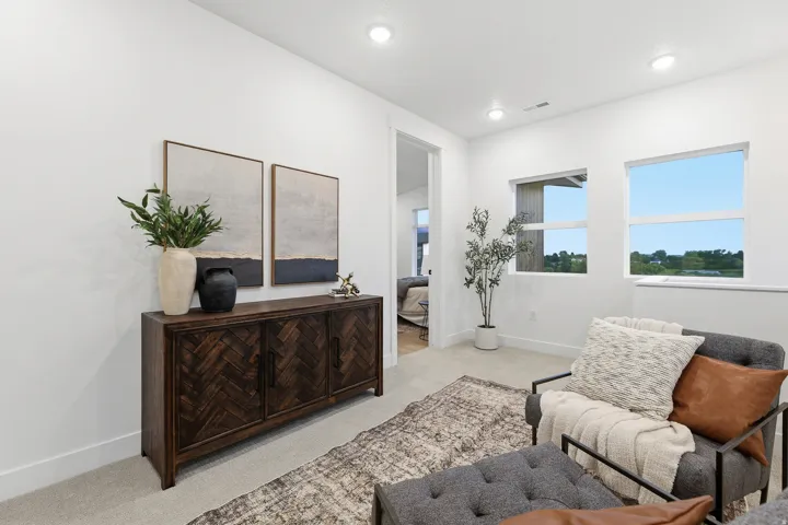 Recessed lighting illuminates neutral walls and carpet flooring