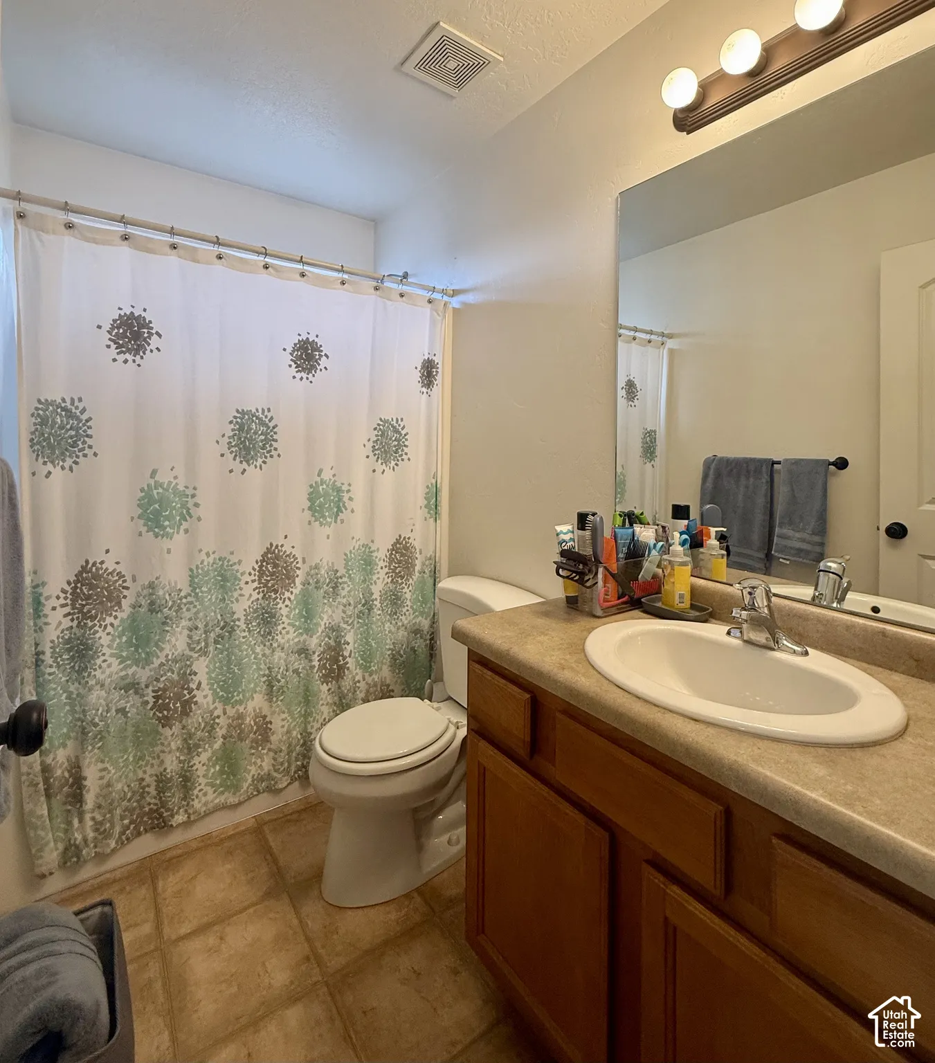 Bathroom featuring a single vanity, integrated sink, and wood-finish cabinetry