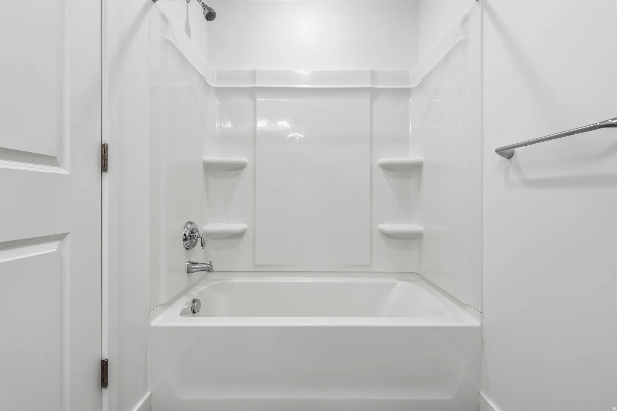 White tub and shower combination with integrated shelving