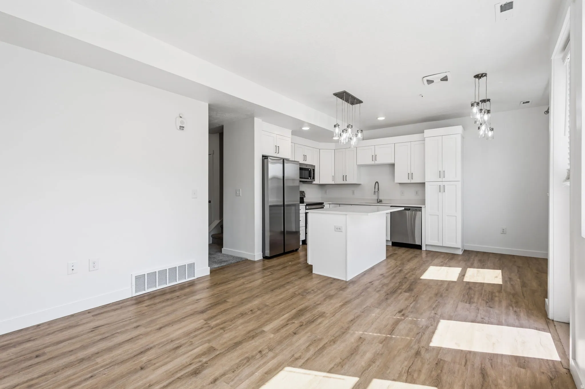 Open-concept living space with wood-finish flooring