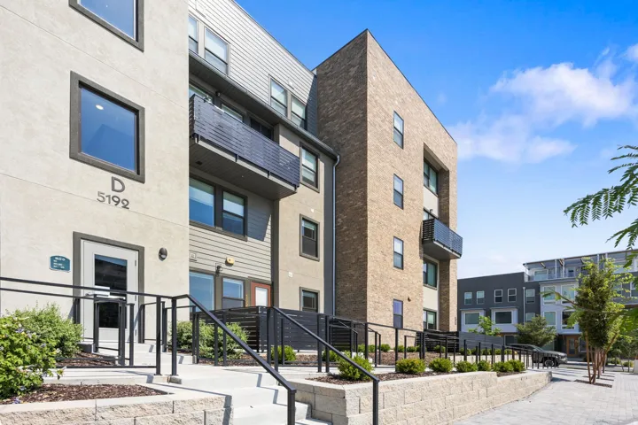 Multi-story building featuring a brick facade, stucco siding, and multiple balconies