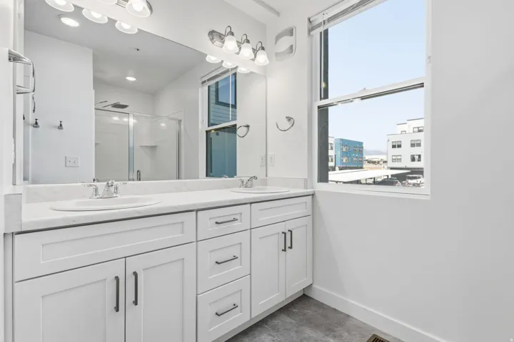 Double vanity with white cabinetry and dark hardware
