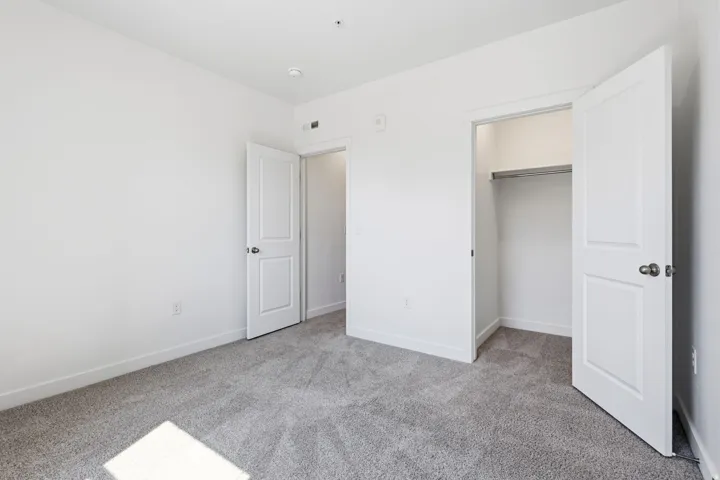 White walls, gray carpeting, and white trim throughout