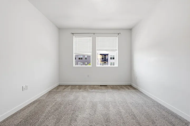 Plush gray carpeting with clean white walls and window blinds