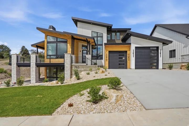 Contemporary architecture featuring a multi-level design, wood-finish siding, and black-framed windows