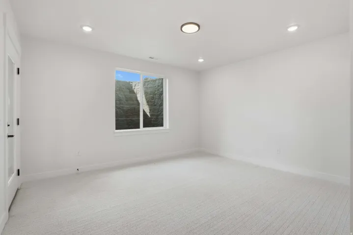 Recessed lighting, wall-to-wall carpeting, and a single-pane window