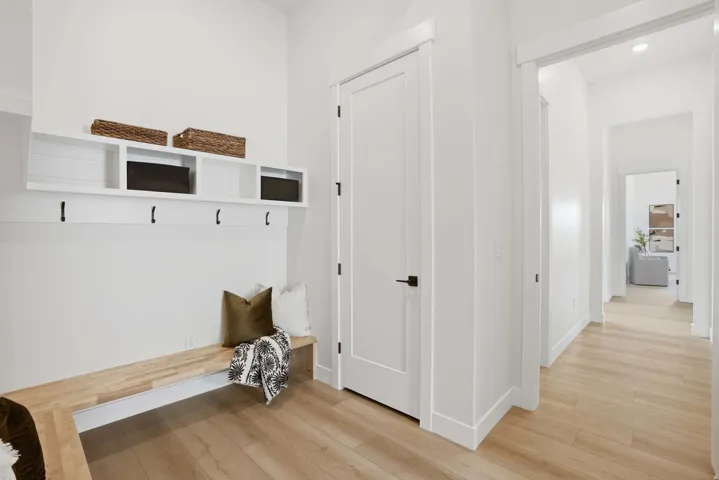 Entryway featuring wood-finish flooring and a built-in bench with integrated shelving and hooks